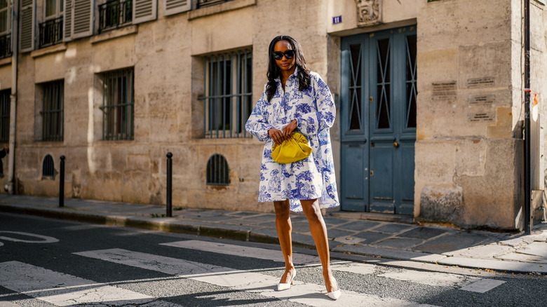 A woman in a shift dress with a yellow purse
