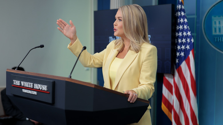 Karoline Leavitt in butter yellow at a podium