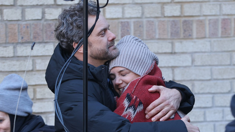 Joshua Jackson and Katie Holmes hug each other on set in 2025