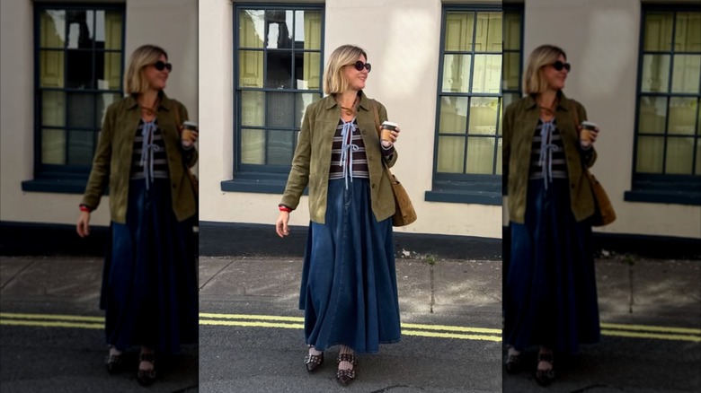 A woman walking in a blue skirt and green suede blazer