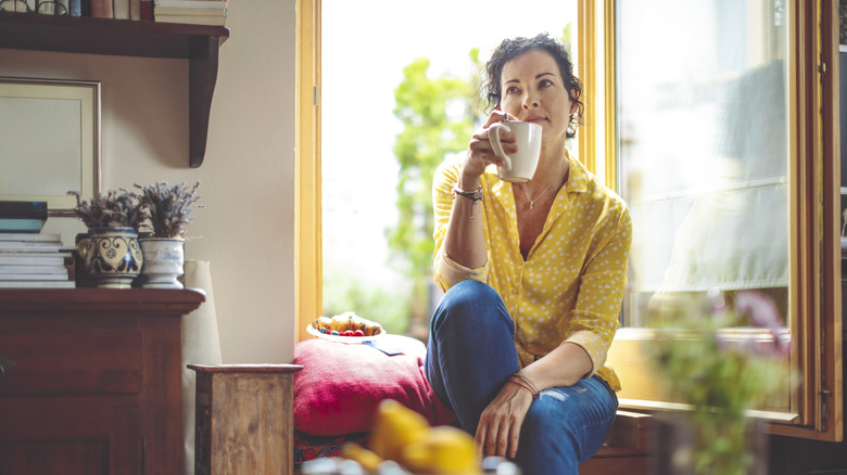 Woman sitting with a mug in deep thought