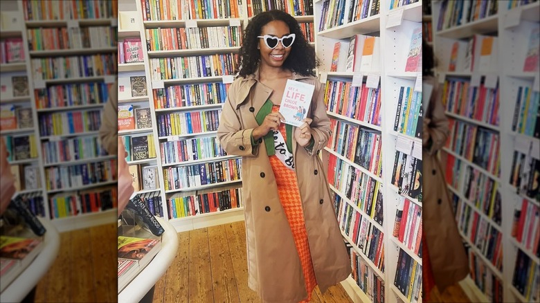 Talia Hibbert holding up her book "Get a Life, Chloe Brown" in a bookstore