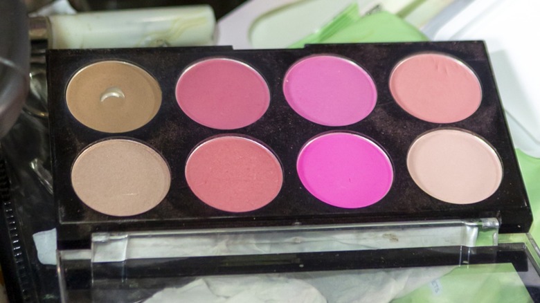A black makeup palette containing multiple shades of blush