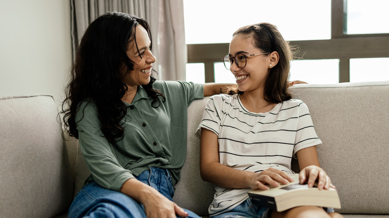 A mother and daughter reading on a couch