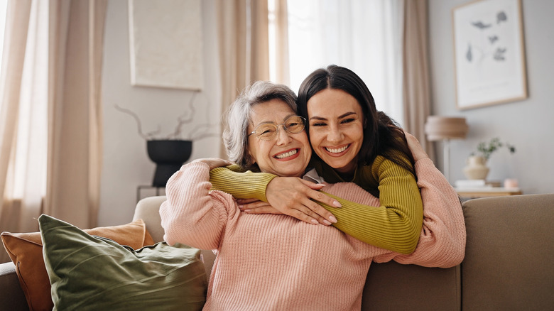 Daughter embracing her mother on the couch