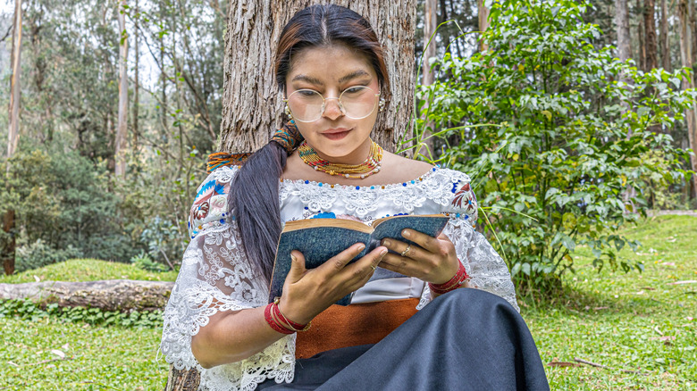 Photo of a young woman reading outside