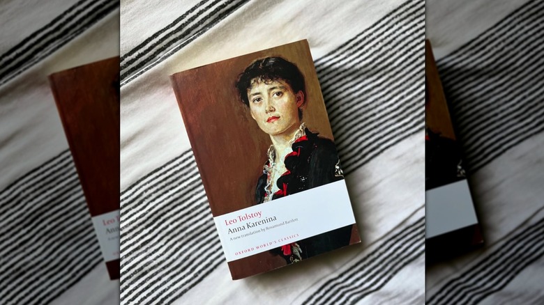 A copy of "Anna Karenina" laying on a striped cloth