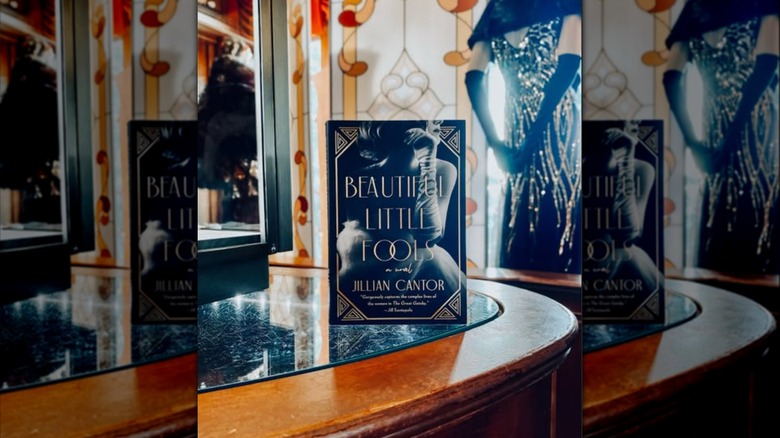 A copy of "Beautiful Little Fools" with stained glass behind it