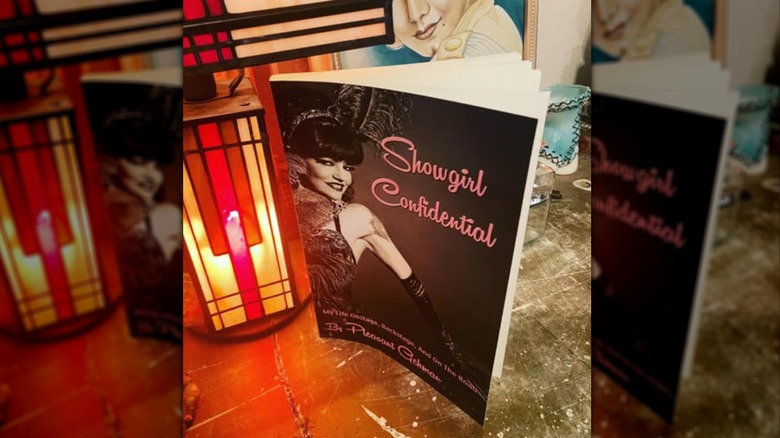 A copy of "Showgirl Confidential" on a table with a lantern behind it