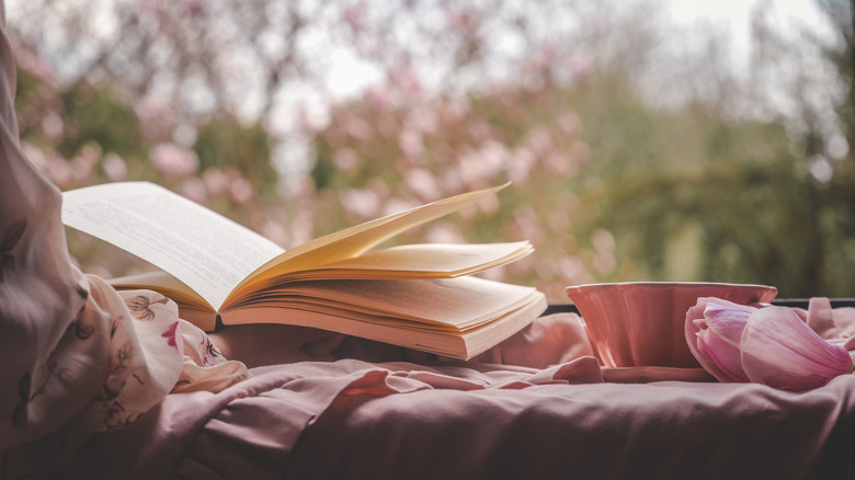Book with teacup and magnolia petals