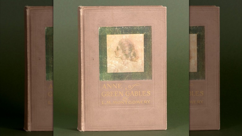 A old edition of the book "Anne of Green Gables" on a green background
