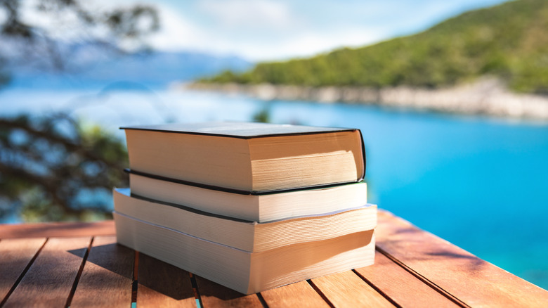 Stack of books with an island beach in the background