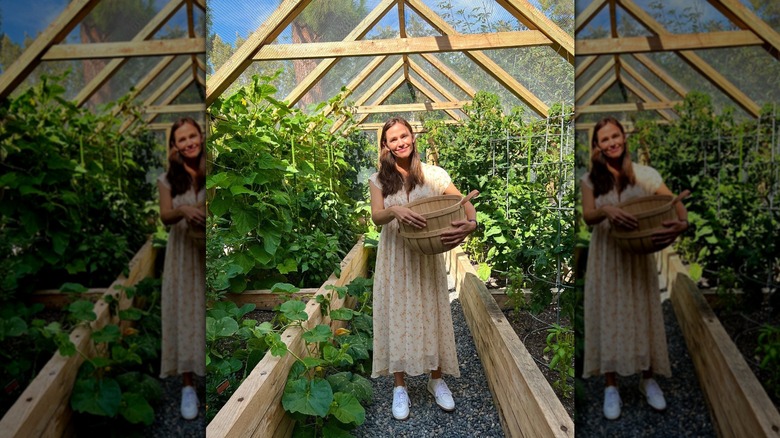Jennifer Garner standing in her garden house while holding a wooden basket