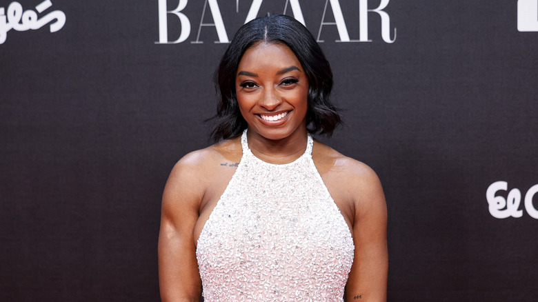 Simone Biles wearing a white dress