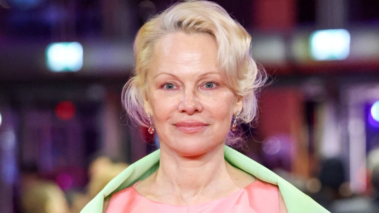 Pamela Anderson posing on the red carpet with minimal makeup
