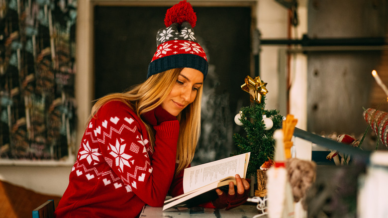 Woman in a holiday sweater reading