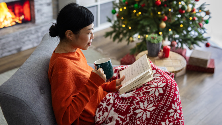 Woman reading by the Christmas tree