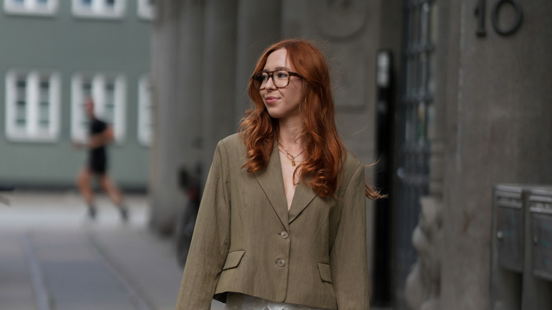 A redheaded woman wearing a khaki green blazer