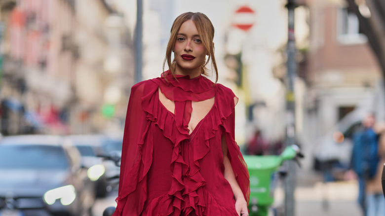 A redheaded woman wearing a red frill dress