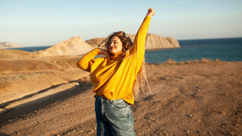 Woman wearing jeans in a seaside field