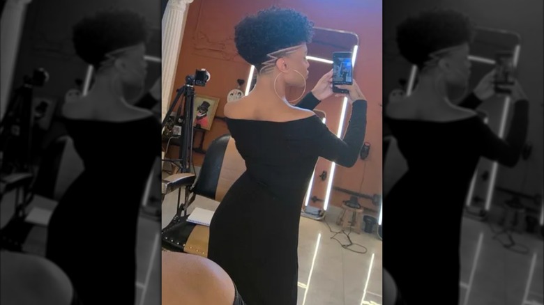 Woman with tappered sides and a curly frohawk on top