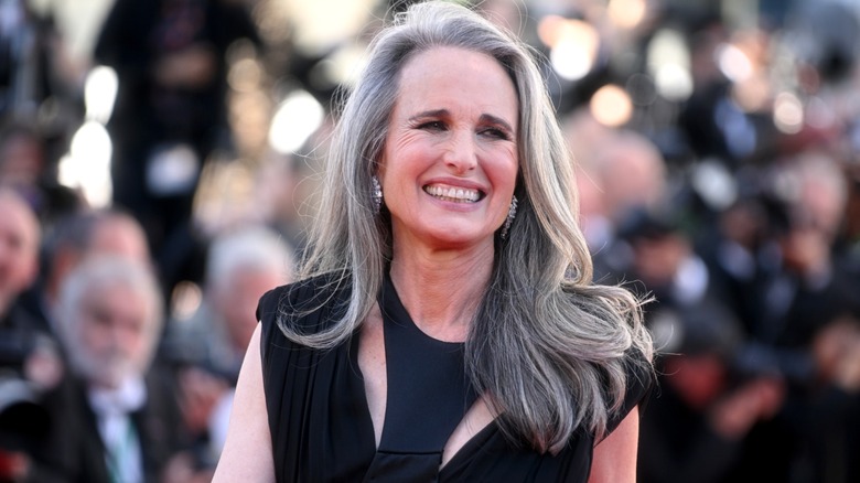 Andie MacDowell smiling on the red carpet in a black dress