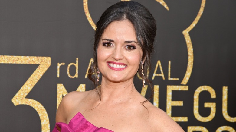 Danica McKellar smiling on the red carpet in a pink dress