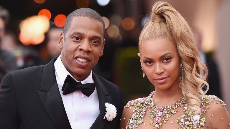 Jay-Z leaning in for a photo with Beyonce on the red carpet
