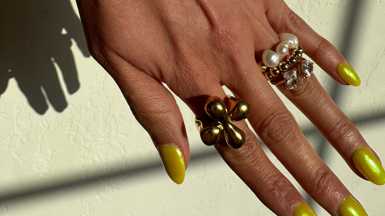 Hand with metal and pearl rings 