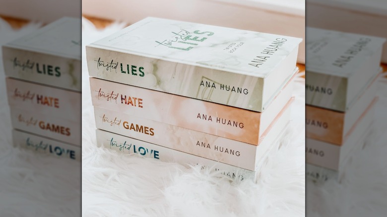 The Twisted series books stacked up top of a fuzzy white cloth