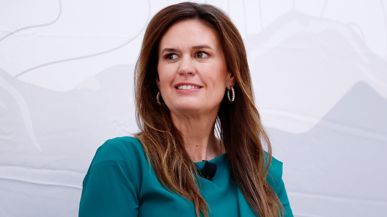 Sarah Huckabee Sanders wearing green and looking to the side