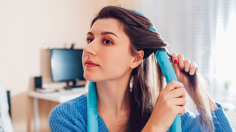 A woman using a heatless roller