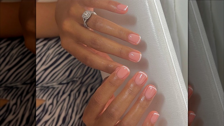 A woman's hands with a short, French manicure