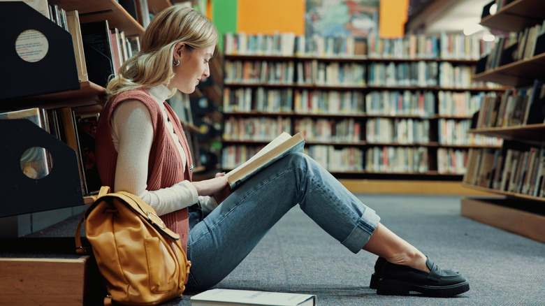 Person reading on the floor of a library