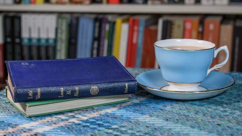 Stack of Louisa May Alcott books with a cup of tea