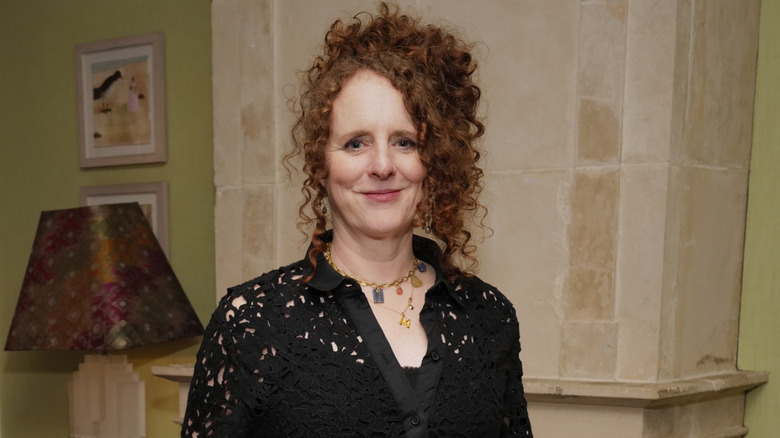 Maggie O'Farrell smiling in a black lace shirt and an updo