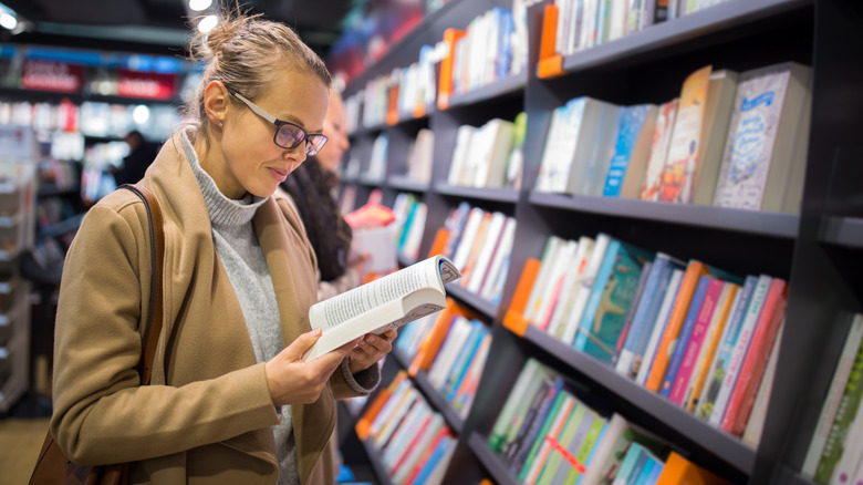 Woman with glasses looking at a book