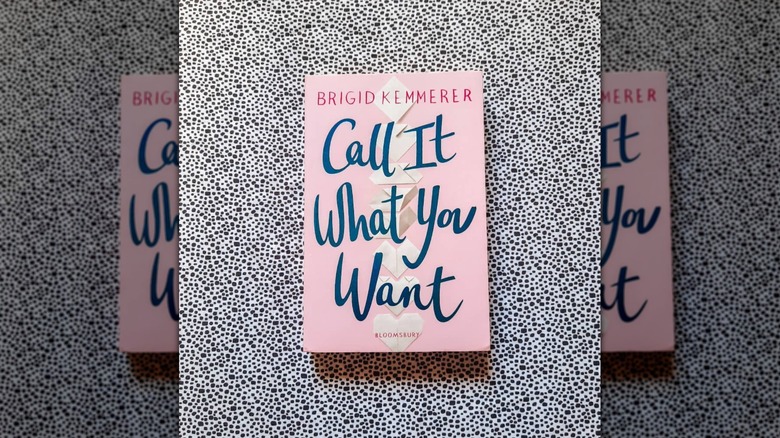 A copy of "Call It What You Want" laying on a black and white speckled sheet