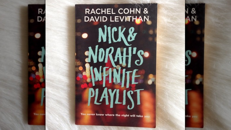 A copy of "Nick & Norah's Infinite Playlist" laying on a fluffy white background