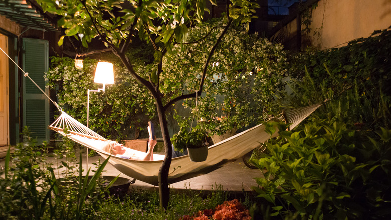 Woman reading outside in hammock