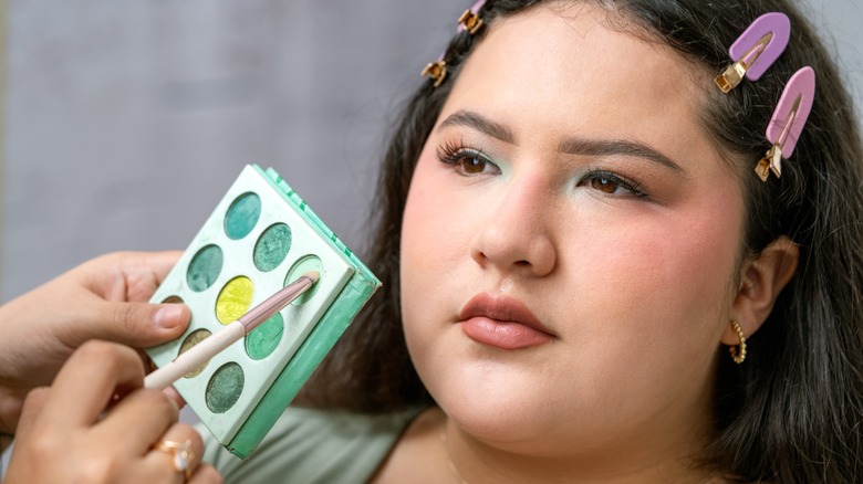 A woman with hooded eyes having eyeshadow applied to her eyelids