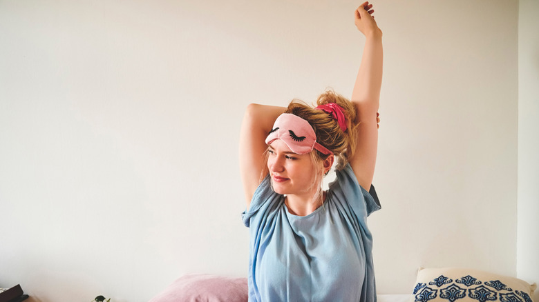 A woman stretching in bed in the morning