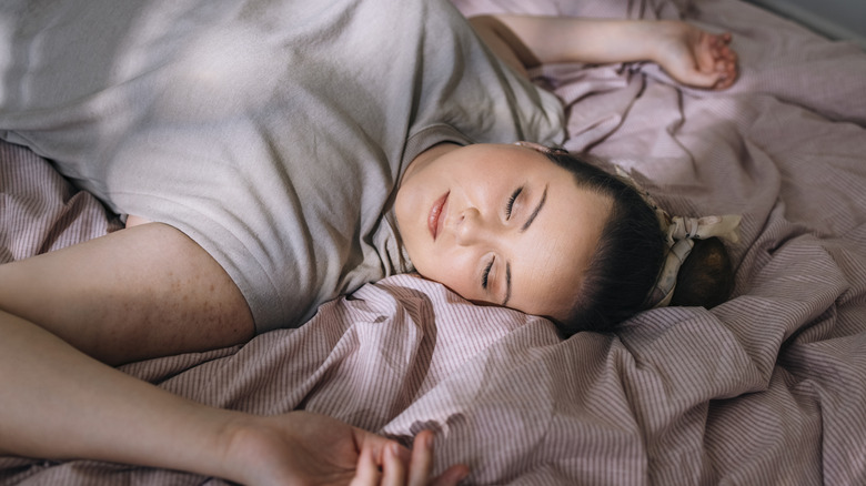 A woman asleep with a bun in her hair