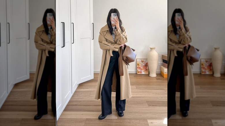 Woman wearing black pants and slim loafers with trenchcoat
