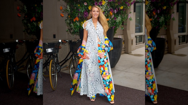 Blake Lively on the sidewalk in a black and white dotted dress with colorful, graphic pants
