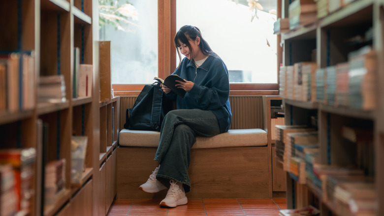 Woman with a stack of small books on her head