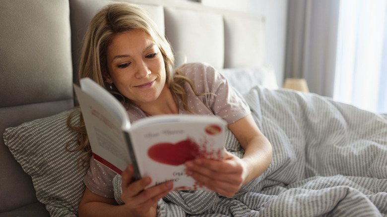 Woman reading a book in bed