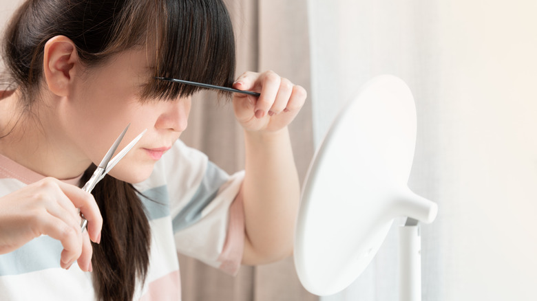 Woman cutting bangs