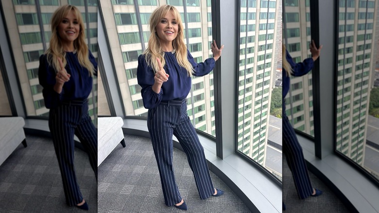 Reese Witherspoon posing in front of a window with curtain bangs