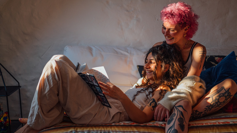 Queer femme couple reading in bed